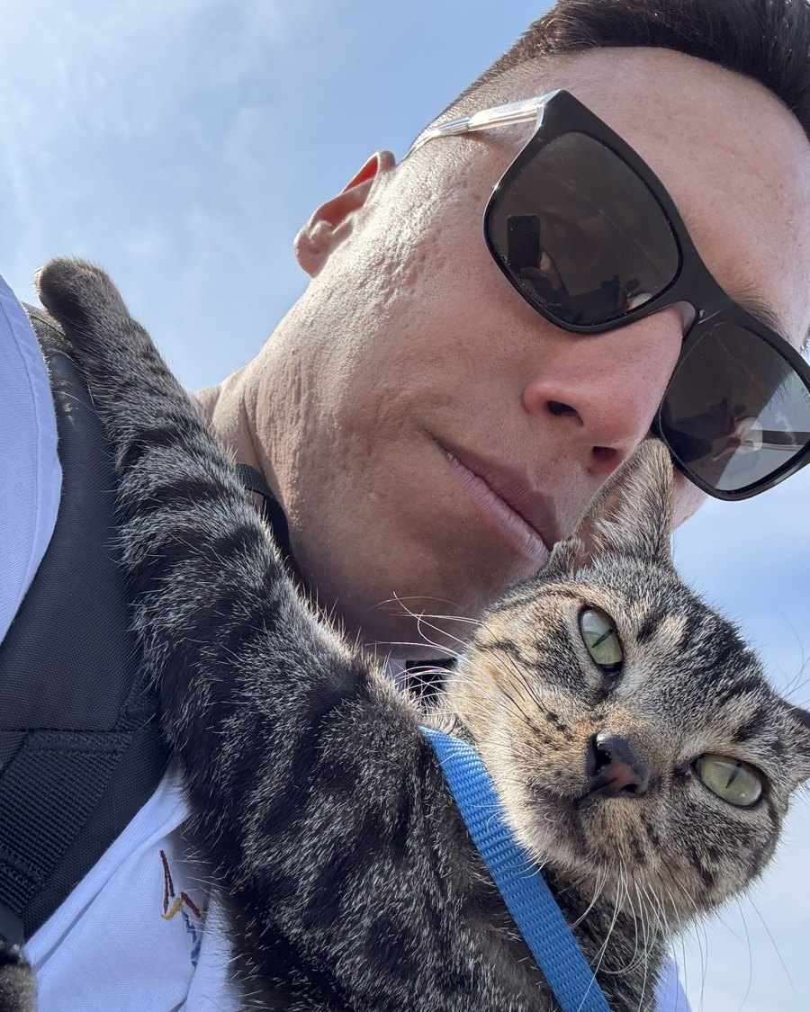 Josh outdoors with his cat Nyx in a harness